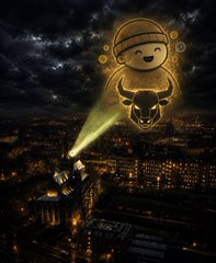 A glowing, golden translucent baby figure with an angry expression projecting a searchlight over a dark city skyline at night.