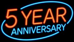 A glowing neon-style graphic with red and blue text reading '5 YEAR ANNIVERSARY' inside an oval shape on a black background.