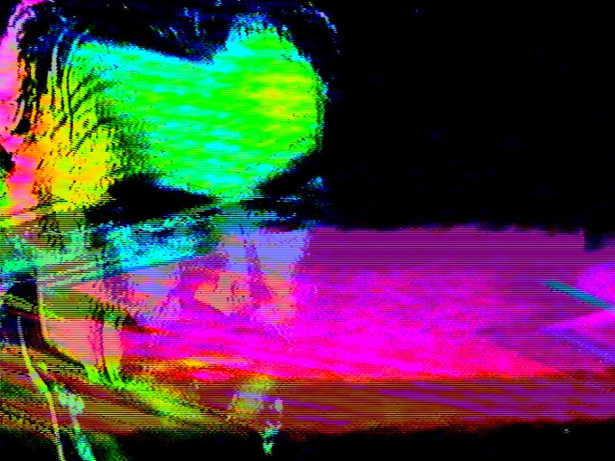 A distorted, glitched digital image with bright neon green, pink, and yellow horizontal bands of static and noise against a black background.