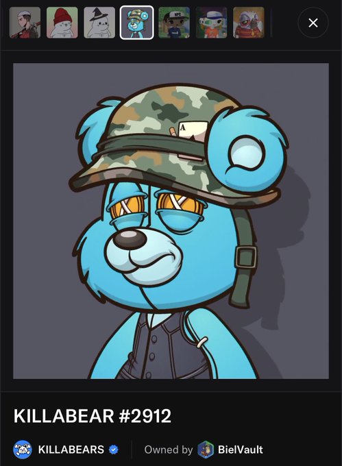 A digital NFT image of a blue bear character wearing a camo cap and sunglasses, labeled "KILLABEAR #2912" and owned by "BielVault".