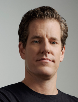 Cameron Winklevoss, co-founder of the crypto exchange Gemini, is shown in a headshot wearing a black shirt against a gray background. The image accompanies his commentary about Bitcoin's recent dip to $65k, which he views as an "unprecedented time to buy," tying his public persona as a prominent crypto investor directly to his bullish market outlook.