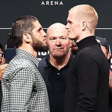 Two fighters, presumably Islam Makhachev and Ian Garry, face off intensely during a pre-fight staredown, with the word "ARENA" visible in the background and a man standing between them overseeing the moment. This image captures the tension between the two competitors before their matchup, which is being analyzed for its likelihood of going the distance based on each fighter's recent record.