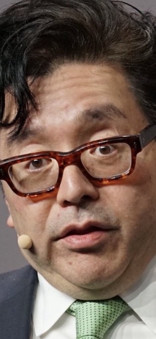 The image features a man wearing glasses, a suit, and a green tie with his head turned towards the camera. The caption reads "Tom Lee:卧槽ETH能这么跌啊". This suggests that Tom Lee is an expert in the field of ethics or philosophy, as indicated by his name tag.