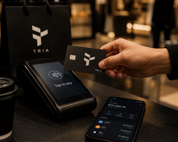 A lifestyle marketing image showing a person tapping a TRIA branded card on a contactless payment terminal, with a phone displaying a crypto portfolio showing $12,450.75 with assets including USDC, BTC, and SOL.
