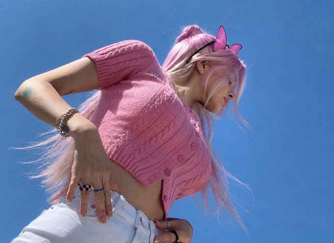 A young woman with pink hair and butterfly accessories poses against a bright blue sky, embodying the hopeful yet uncertain sentiment of the post about Web3 in 2026.