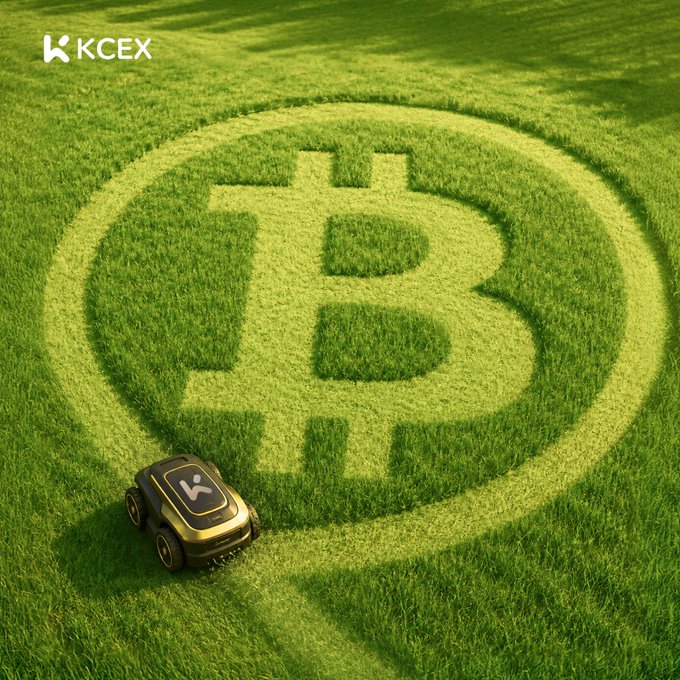 A robotic lawnmower with the "KCEX" logo is cutting a Bitcoin symbol into a grassy field, with "KCEX" displayed in the top left corner.