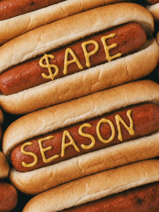 Hot dogs in buns are stacked together, with mustard squiggles spelling out "$APE" and "SEASON" across two of them, visually tying the food pun to the "$APE Season" post.