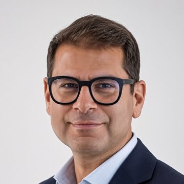 A man wearing black-rimmed glasses and a dark suit over a light blue shirt is pictured in a professional headshot against a plain background. The image likely depicts Gilbert Verdian, the founder of Quant ($QNT), in connection with the post claiming he is selling his tokens.