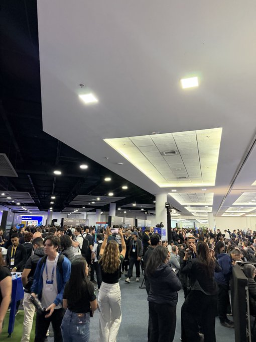 A packed convention hall teems with attendees at a crypto conference, with visible signage for "Terra" and "BSC" booths in the background. The dense crowd and buzzing atmosphere directly counter the claim that "crypto is dead," showcasing strong industry engagement and enthusiasm.