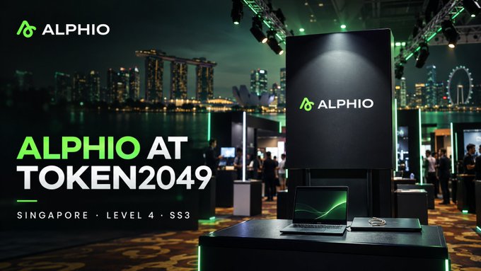 A promotional banner for 'ALPHIO AT TOKEN2049' in Singapore (Level 4, SS3), featuring a black booth with the company's green logo against a backdrop of the Singapore skyline at night.