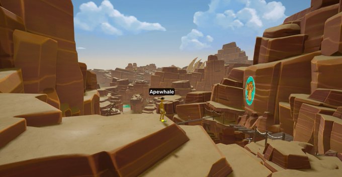 A 3D video game landscape featuring rocky, canyon-like terrain with a character labeled 'Apewhale' standing on a ledge near some structures and a mural.