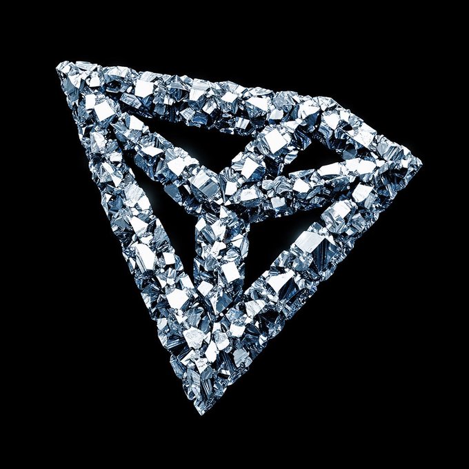 A 3D rendered geometric design features a triangular shape made of clustered blue crystals or diamonds on a black background.