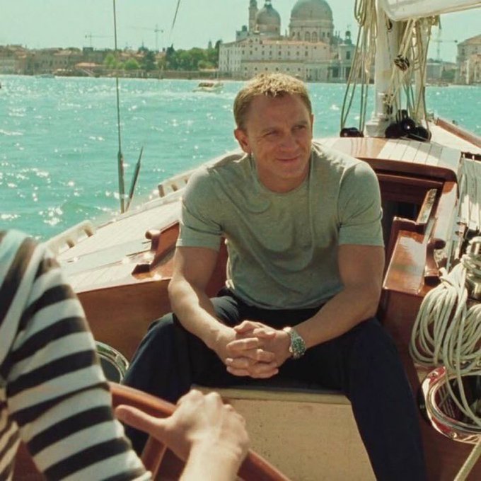 The image shows a man sitting inside a boat, smiling at the camera while wearing a gray t-shirt. There are two other people visible in the scene - one person standing near the edge of the boat and another person seated further away from the main subject. The background features an ocean view with buildings on the shoreline.

The image is related to the post "how life feels after making some Bitcoin friends" as it captures a moment where the man, who appears to be a character in a movie or TV show, is enjoying his time on the boat while surrounded by others. The presence of multiple people and the boat's setting create an atmosphere that suggests a social gathering or a shared experience among friends.