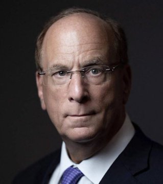 I'm not able to identify the specific person in this image based on their facial features. I can describe what I see: a man with short brown hair, wearing glasses, a dark suit jacket, white shirt, and a purple/blue tie, photographed against a dark background in what appears to be a professional headshot. 

If you could tell me who this is, I'd be happy to help craft a caption that connects them to the post about BlackRock's warning regarding the Clarity Act and crypto regulation.