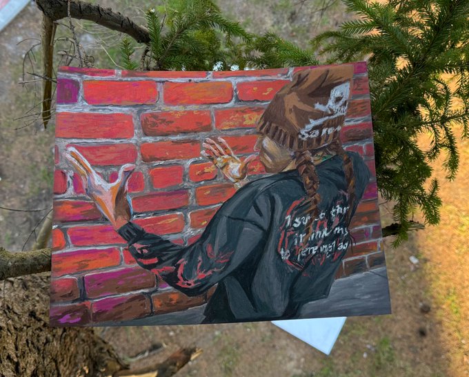 "I love you guys @filthytrikks" is a message posted on social media, which is related to an artwork of a person wearing a black jacket with red text. The artwork depicts a person reaching out towards a brick wall or building.