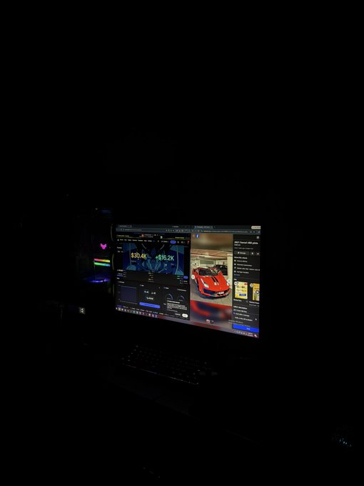 A laptop in a dark room displaying what appears to be a website or dashboard showing cryptocurrency prices ($30.4K and $66.2K) and a red sports car image, with subtle RGB lighting visible.