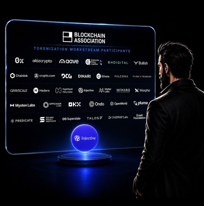 A man viewing a digital display showing the 'BLOCKCHAIN ASSOCIATION TOKENIZATION WORKSTREAM PARTICIPANTS' with Injective highlighted, featuring companies like 0x, Aave, Chainlink, Grayscale, Solana, and Uniswap Labs.