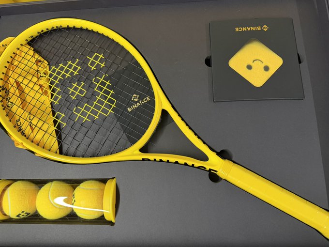A bright yellow Binance-branded tennis racket and tennis balls are displayed alongside a Binance VIP gift box, reflecting the post's message about receiving premium perks from Binance ("表哥" and "一姐") as a VIP user.