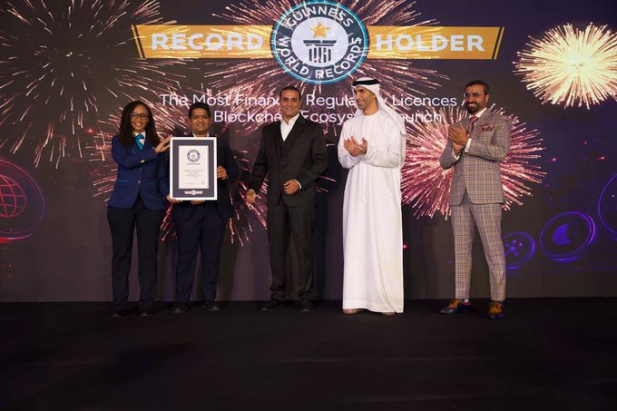 Five representatives stand on stage holding a framed certificate alongside the "GUINNESS WORLD RECORDS HOLDER" banner for "The Most Financial Regulatory Licences" record, celebrating Blockmaze RWA's achievement of securing the most financial regulatory licences at launch as part of the RWA (Real World Assets) sector's growth.