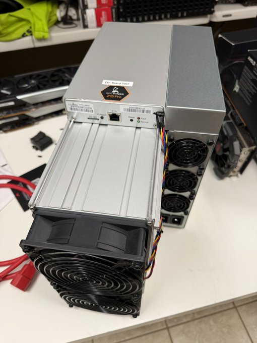 A Bitmain Antminer Z15 Pro ASIC miner sits on a workbench with its cover removed, exposing the internal hash boards and power supply unit with visible warning labels reading "KEEP DRY" and "HIGH VOLTAGE." The image illustrates the post about selling the Z15 Pro miner for top dollar, showing the disassembled Equihash mining hardware.