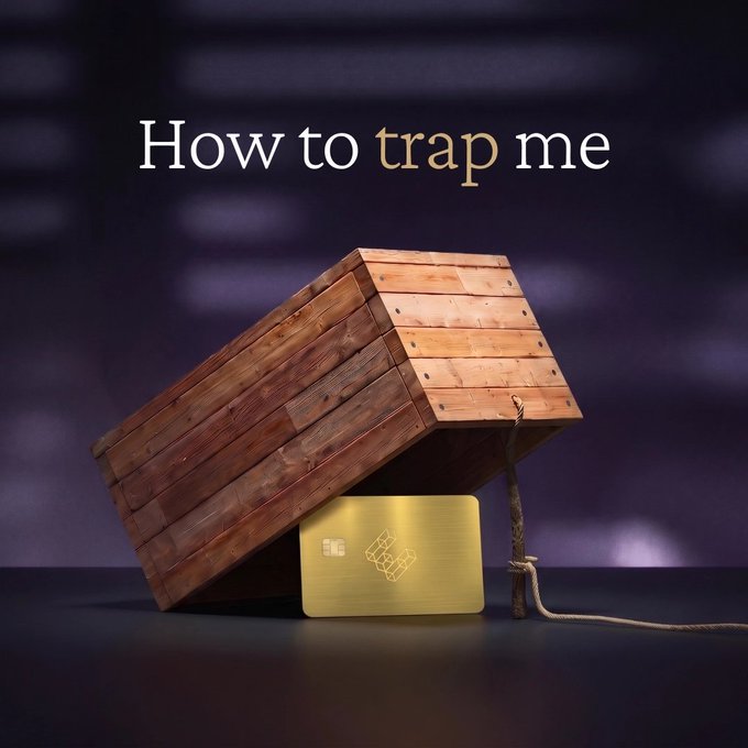 A tilted wooden box propped up by a stick with a rope attached sits next to a gold credit card, with the text "How to trap me" displayed above. The image plays on the post's humor by suggesting that a premium gold credit card would easily lure someone into the classic box-and-stick trap.