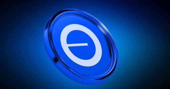 The image features a blue coin with an "e" symbol on it. The coin has a metallic sheen and appears to be floating or hovering above the frame. It's positioned centrally within the image, drawing attention as the main focus. The background is dark blue, which contrasts with the light blue of the coin. The text in the image reads: "Good Evening X Community @base offers low fees, Ethereum security, and seamless @coinbase integration It’s built for mass adoption, empowering developers to create fast, user-friendly dApps".