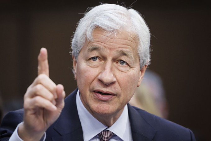 The image shows Jamie Dimon, CEO of JP Morgan Chase, gesturing with his raised index finger while speaking, likely during a Congressional testimony or formal appearance. The accompanying post references his statement about Michael Saylor's $3 billion cash reserves signaling the end of the Bitcoin bear market, framing Dimon's remarks as bullish for BTC.