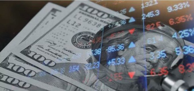 A stack of U.S. $100 bills is shown beneath a magnifying glass overlaid with red and blue stock market numbers and percentages (such as "245.3", "9.33%", and "6.35%"), symbolizing scrutiny of the traditional U.S. financial system. The image visually reinforces the post's claim that the Fed and dollar-based economy have reached a critical turning point, with the magnified currency and fluctuating figures suggesting volatility and collapse of the old monetary order.