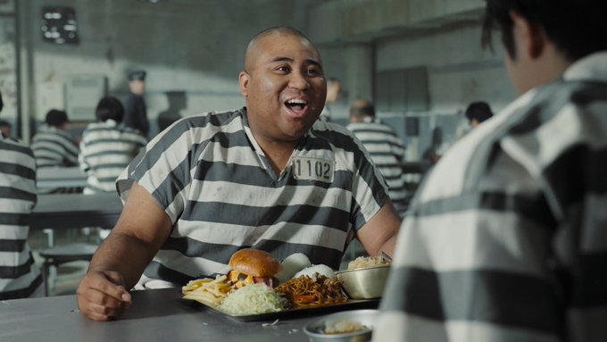 The image shows two men sitting at a table with food, including a hamburger and a plate of vegetables like broccoli. The scene appears to be set in an office environment where multiple people are present. There is also a person standing behind one of the men who has their back turned towards the camera. The post about infrastructure for innovation emphasizes the importance of creating secure digital environments that can support new technologies, such as blockchain and cryptocurrencies. This ensures that innovations can thrive without compromising security or privacy concerns.