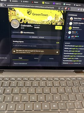 A laptop screen shows the CoinMarketCap website with a GreenTown token page displaying a balance of 0 and $4,600.