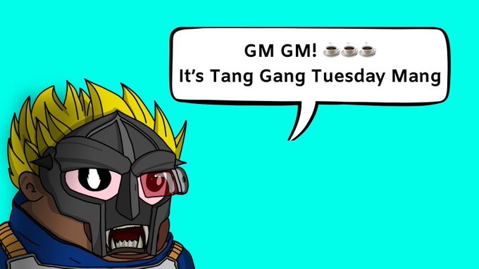 A cartoon character with spiky blonde hair wearing a dark mask with a red eye lens, speaking the dialogue 'GM GM! It's Tang Gang Tuesday Mang' in a speech bubble against a teal background.