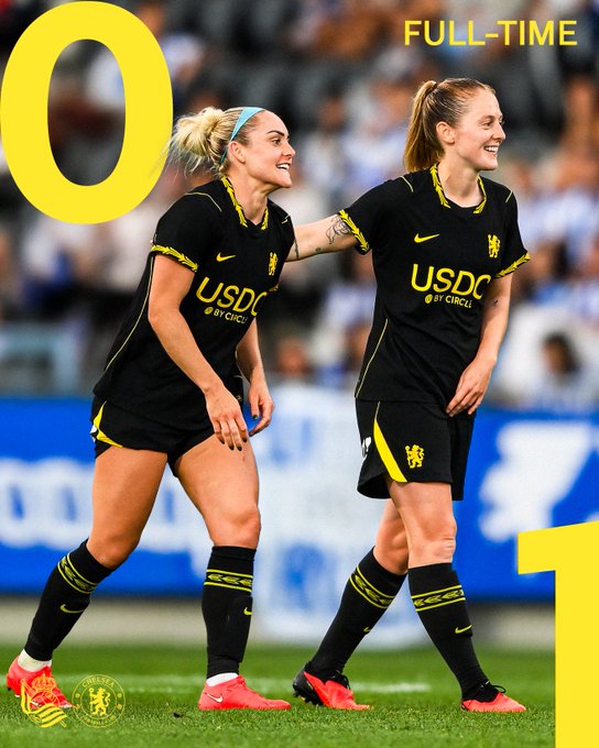 Two Chelsea FC Women players wearing black jerseys with "USDC by Circle" sponsorship logos smile on the pitch, with "0" displayed on the left and "FULL-TIME" on the right, celebrating a 1-0 victory that marks USDC's successful debut as Chelsea FC Women's sponsor.