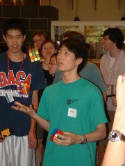 Two young people wearing name tags stand together at what appears to be a camp or conference gathering, with the boy on the left sporting a "BASK" t-shirt. The image has a dated quality suggesting it's from the early 2000s, fitting the post's nostalgic reference to a "summer camp for nerds" from around 20 years ago, jokingly tied to the rise of figures like Sam Bankman-Fried.