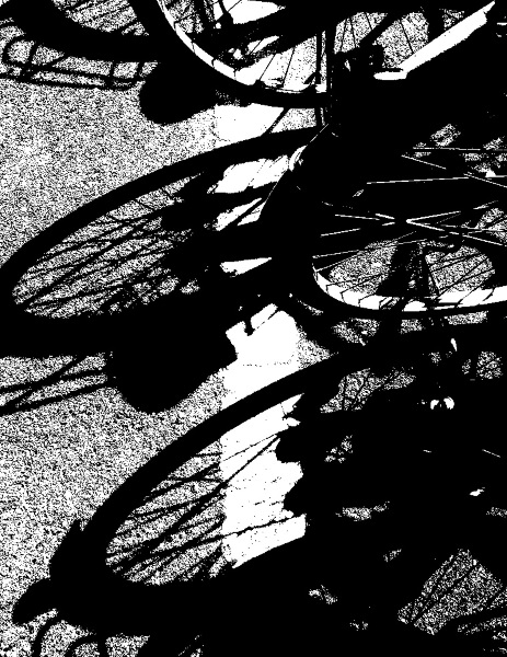 A high-contrast black and white stylized image showing the dark silhouettes of bicycle wheels and frames against a bright, textured background.