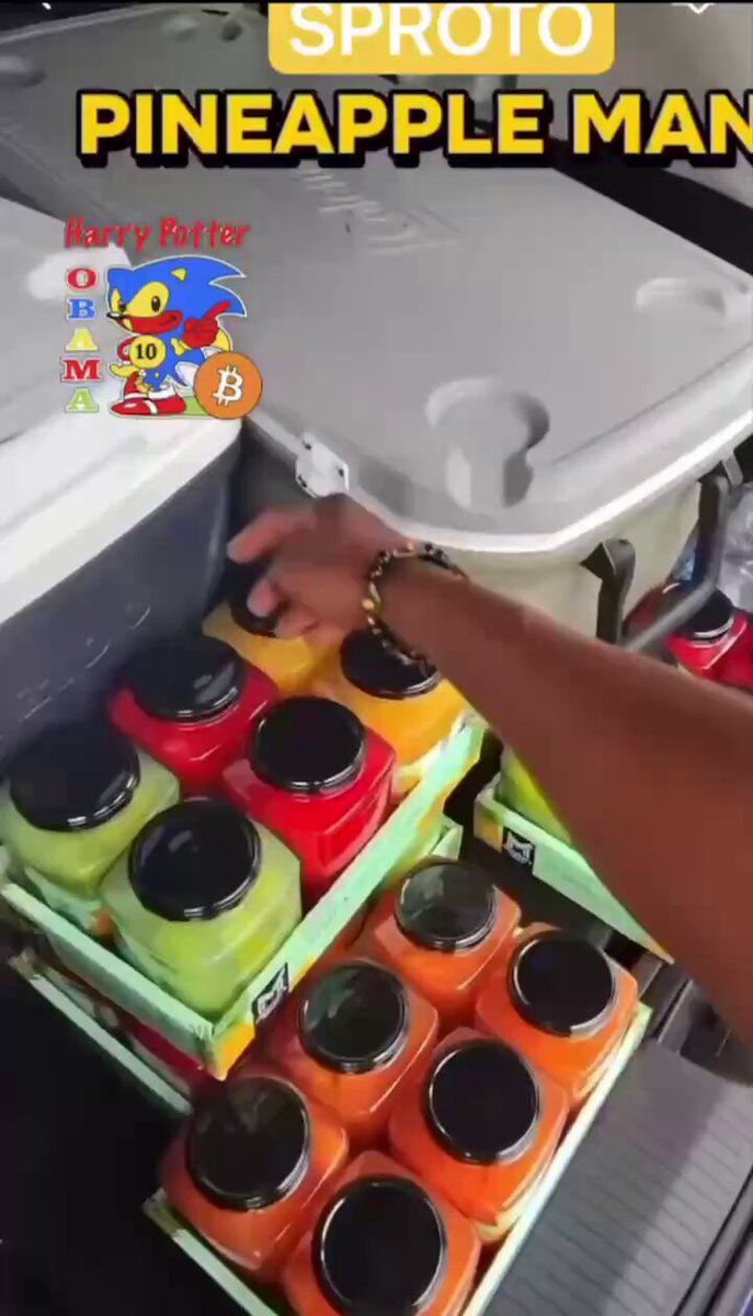 The image features a person reaching into a cooler, pulling out several containers of fruit juice. The fruits include pineapple, apple, and orange juices. There are also other items inside the cooler, such as a bottle and a cup. The background is blurred, but there appears to be a car visible in the scene.