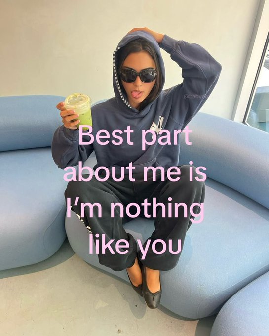 A woman wearing an oversized blue Yankees hoodie and sunglasses sits on a light blue couch holding a drink, with text overlay reading 'Best part about me is I'm nothing like you'.