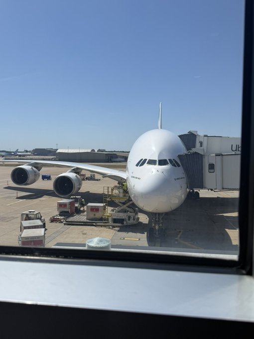 An Airbus A380 is parked at an airport gate, connected to a jet bridge, viewed through a terminal window with ground service vehicles nearby.

The image humorously implies "staking incoming" by suggesting the massive double-decker aircraft—arriving for boarding—represents an incoming stake, tying the aviation scene to the crypto staking announcement for $CARR on RoundaboutDex.