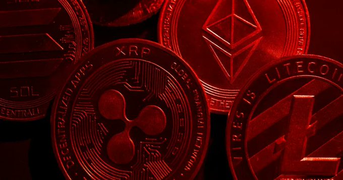 Close-up photograph of physical cryptocurrency coins bathed in red light, showing XRP, Ethereum, Litecoin, and Solana tokens arranged together.