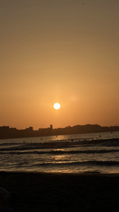 A golden sunset over the ocean silhouettes a distant city skyline along the shore, with the sun hovering low above the horizon as gentle waves roll onto the beach—evoking the calm before a new day, much like the quiet market awaiting its next move.

(Note: No visible text, numbers, tickers, or logos appear in the image itself.)