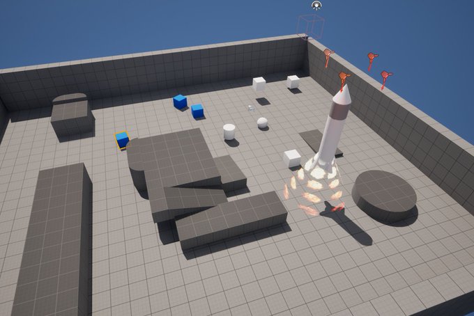 A 3D game environment shows a gray tiled arena with various blocks, platforms, and a rocket launching with flames on a launch pad.