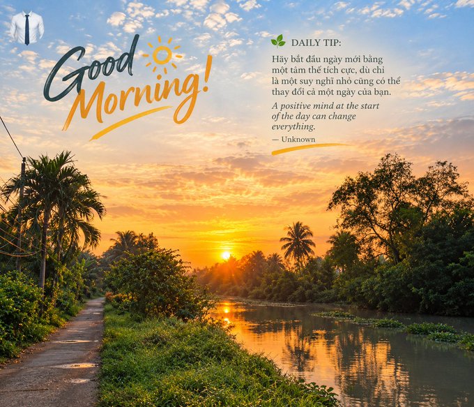 A serene 'Good Morning!' greeting card showing a Vietnamese sunrise over a river with palm trees, featuring a daily tip: 'Hãy bắt đầu ngày mới bằng một tâm thể tích cực' (A positive mind at the start of the day can change everything).