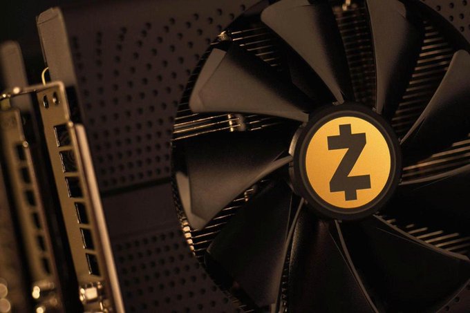 A close-up of a black computer cooling fan with a yellow circular "Z" logo at its center, displayed against a perforated metal surface, representing the new "Zakura" node software and its technical infrastructure for Zcash.