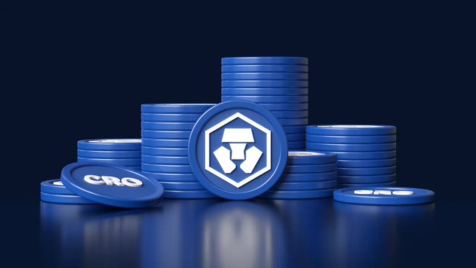 A 3D rendering of stacked blue cryptocurrency coins featuring the Crypto.com (CRO) logo with its distinctive lion emblem, set against a dark blue background.