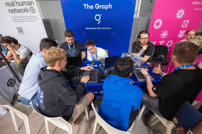 Judges from The Graph ($GRT) huddle around laptops at ETHGlobal Lisbon, reviewing blockchain projects that use subgraphs to index and query onchain data across 40+ chains, competing for a share of $15,000 in prizes.