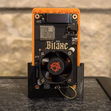 This image shows a "Bitaxe 601" ASIC miner, the same type used by a solo miner who earned a full Bitcoin block reward of 3.138 BTC. The "SOLO SATOSHI" text on the device highlights the improbable feat achieved by this small miner.