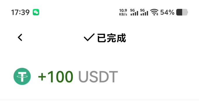 A mobile phone screenshot in Chinese displays a completed transaction showing '+100 USDT' with a green checkmark and '已完成' (completed) text at 17:39.