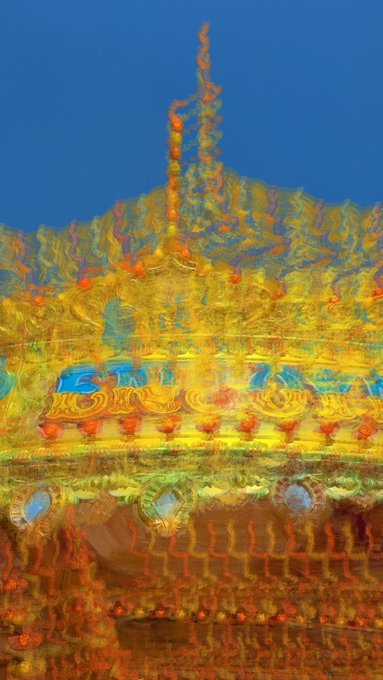An abstract, glitchy, and colorful digital rendering of what appears to be an ornate traditional Asian temple or architectural structure against a blue background.