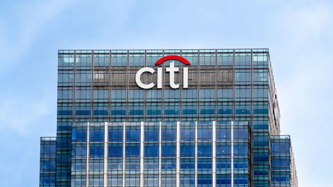 The image features a very tall building prominently displaying the "CITI" logo at its top. The surrounding area appears to be cloudy, suggesting an overcast day. The phrase "BULLISH" could possibly refer to an optimistic viewpoint or description of the CITI company's prospects in the future. In addition, there is another text that reads: "BULLISH: Citi names Chainlink CCIP as the interoperability standard for the tokenized economy." This information implies a connection between CITI and Chainlink.