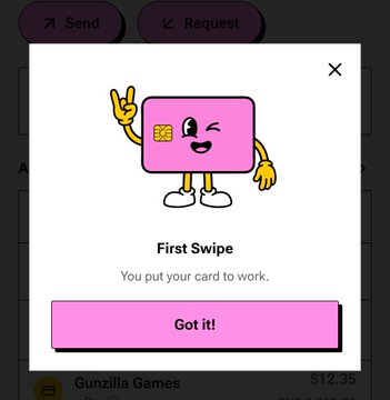 A mobile app popup notification featuring a pink credit card cartoon character saying 'First Swipe - You put your card to work' with a 'Got it!' confirmation button.