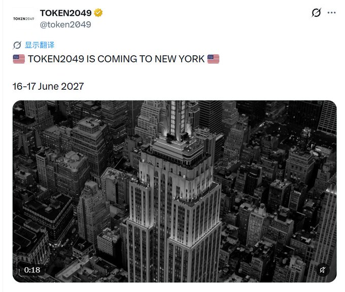 A post by verified account TOKEN2049 (@token2049) announces '🇺🇸 TOKEN2049 IS COMING TO NEW YORK 🇺🇸' for '16-17 June 2027' alongside an aerial video of a skyscraper.